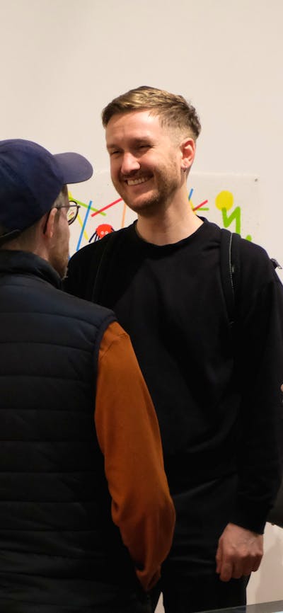 Four people talk in a gallery