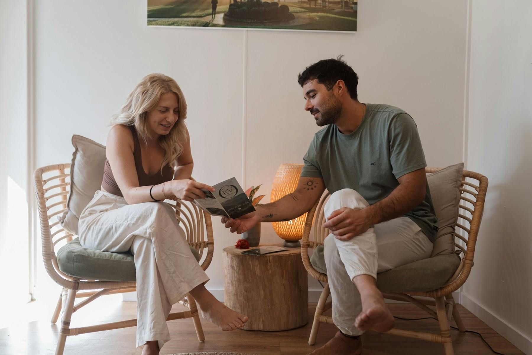 한 커플이 KV 웰니스 대기실에 앉아 치료 안내서를 함께 살펴보고 있습니다.