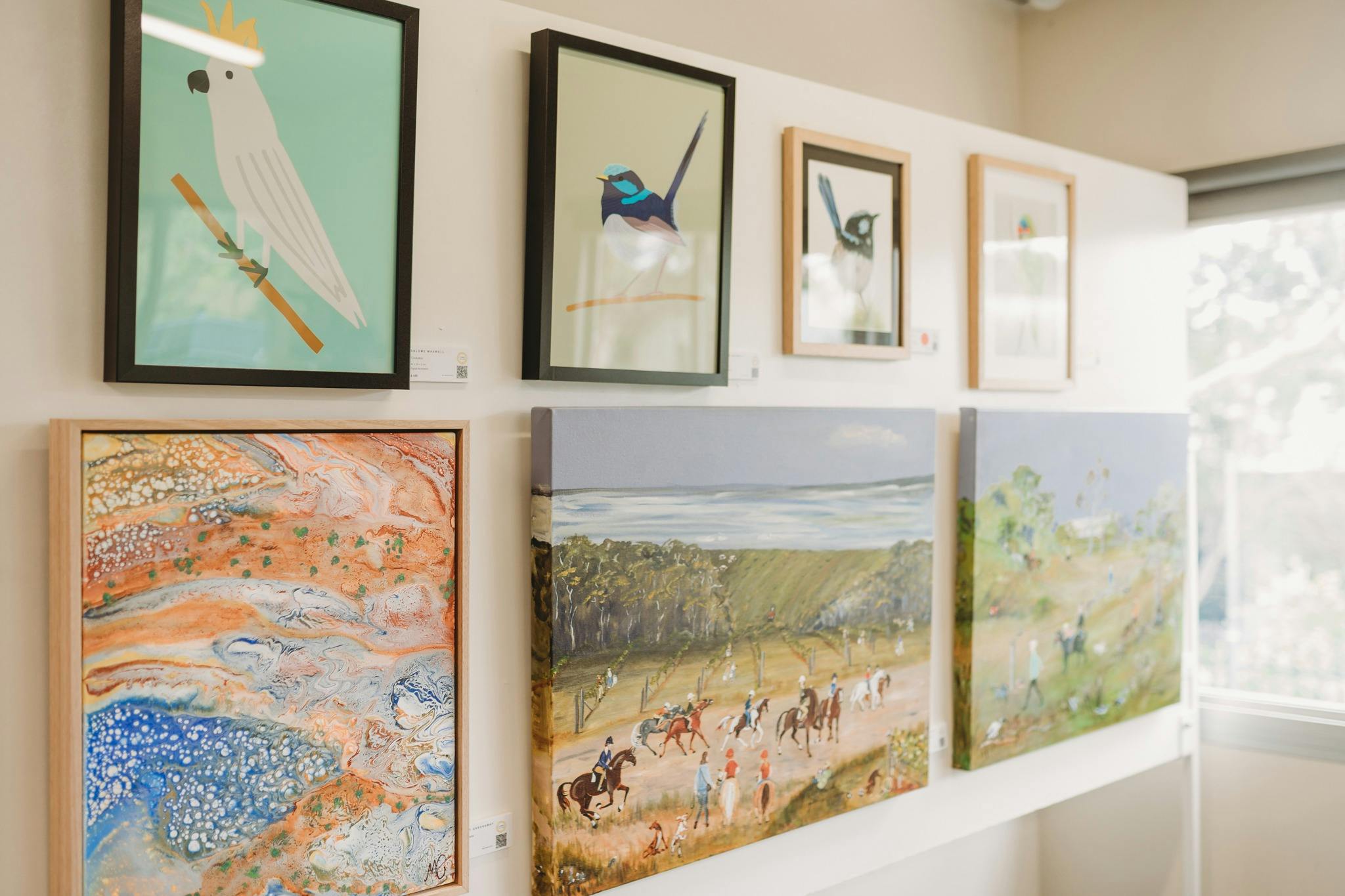 Various artworks at an exhibition, depicting birdlife and landscapes
