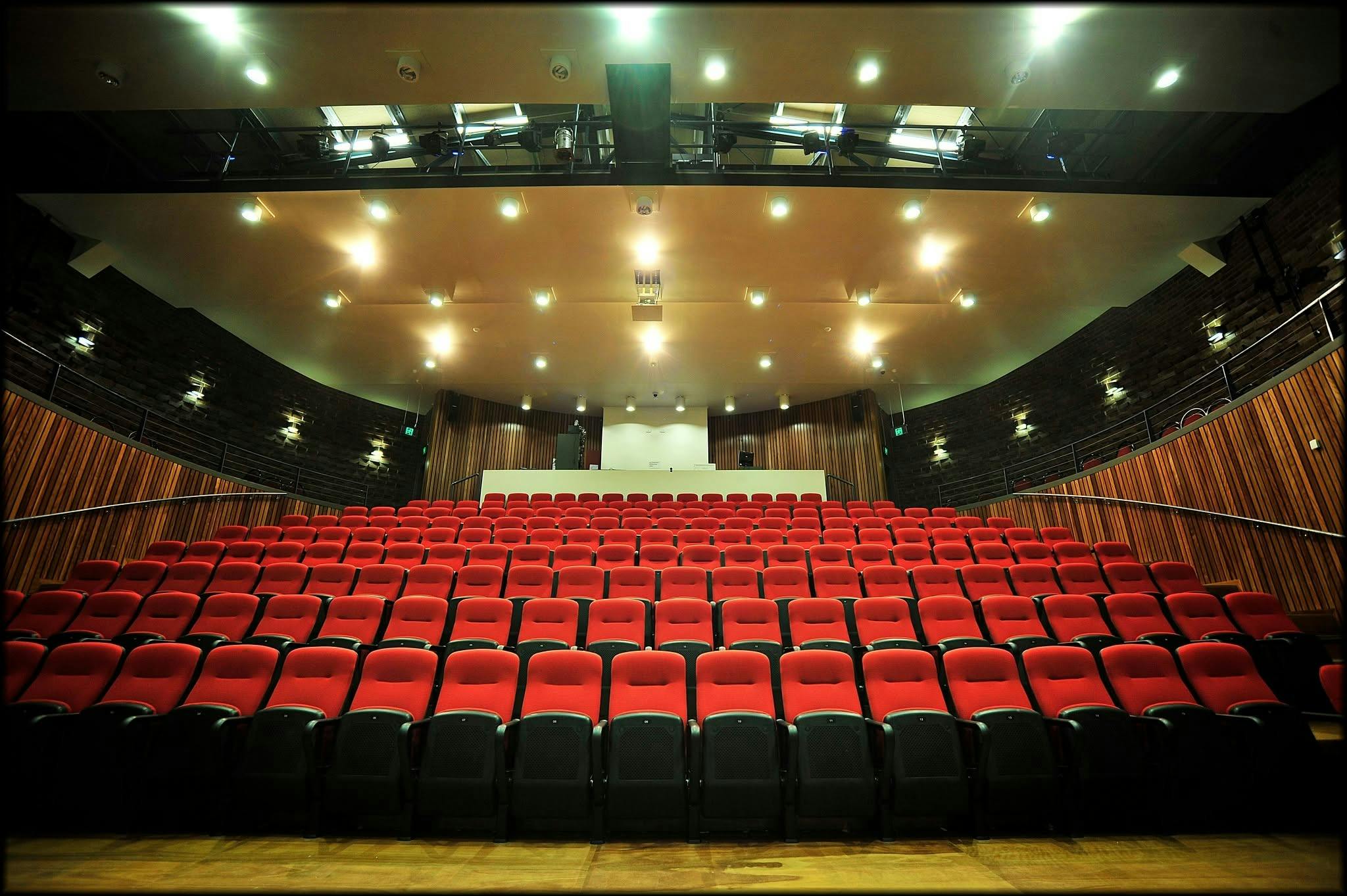 A photo of the red theatre chairs inside of the Theatre