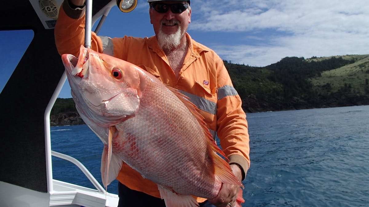Keen angler in the boat, holding up a very large red throat emperor.