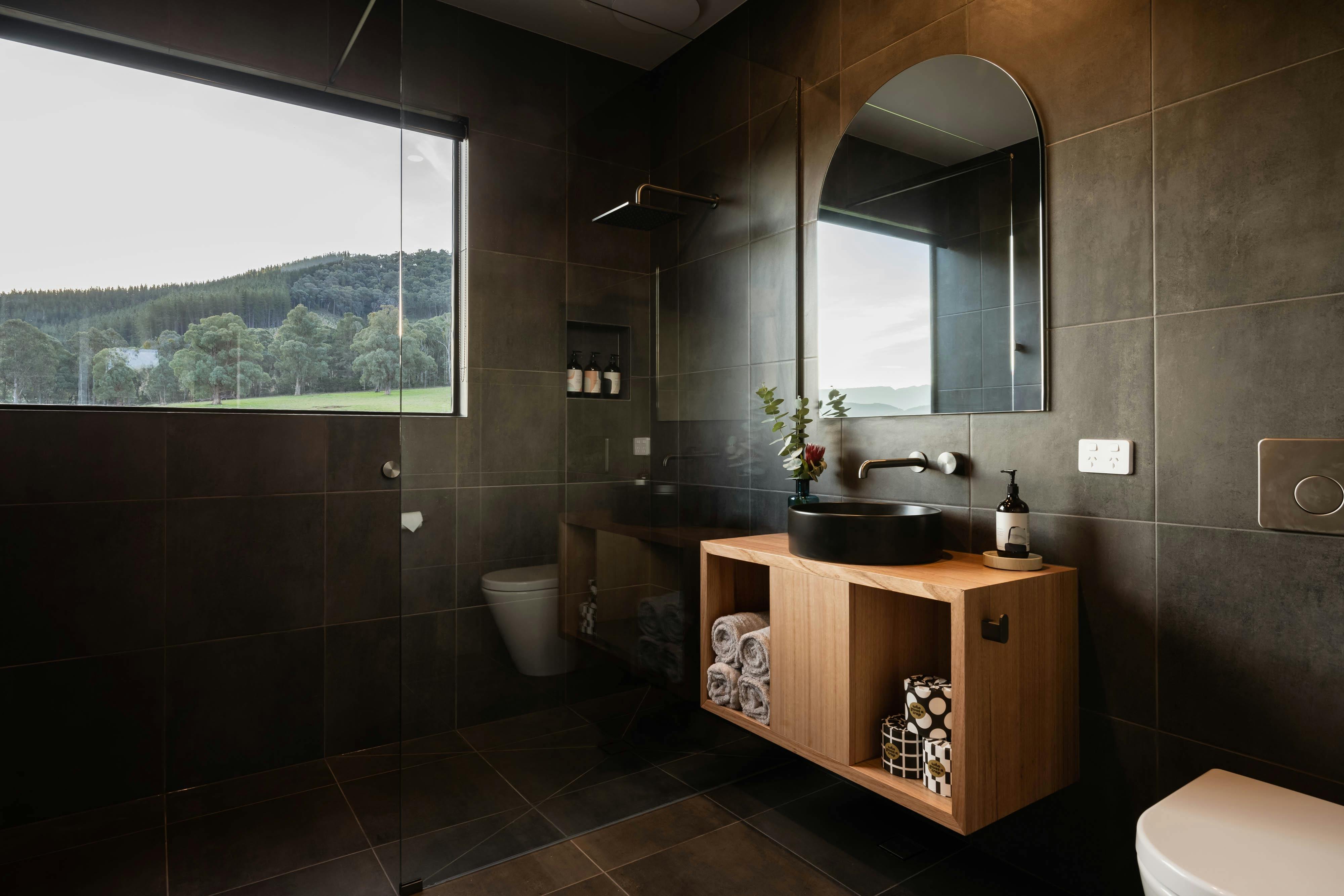 Bathroom with large window in shower with mountain views