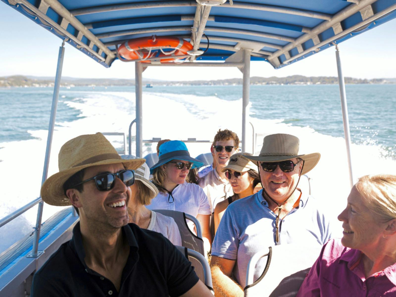 Lächelnder Gast auf einem Boot, das durch das Wasser gleitet