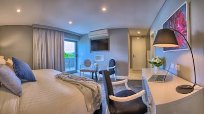 Spacious bedroom featuring a sitting area and a private balcony