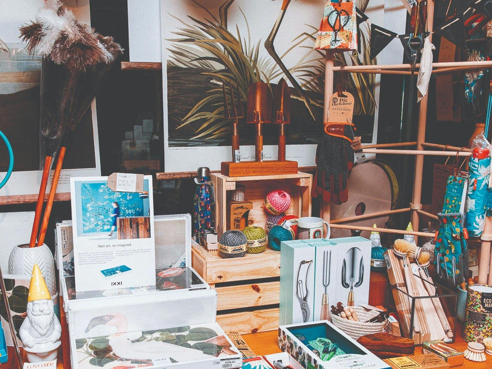 Shop display of gardening tools, feather dusters and artwork