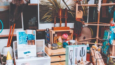 Shop display of gardening tools, feather dusters and artwork