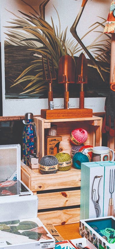 Shop display of gardening tools, feather dusters and artwork