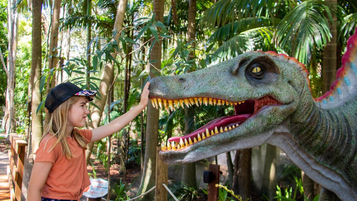 Young girl petting dinosaur at Currumbin Wildlife Sanctuary