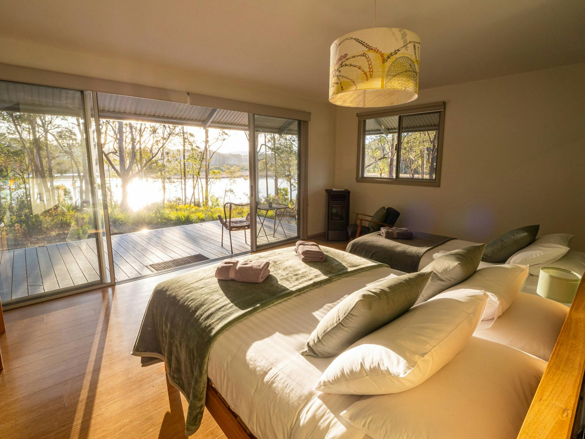 Inside Eco-cabin featuring two beds, heater, private deck overlooking forest and lagoon