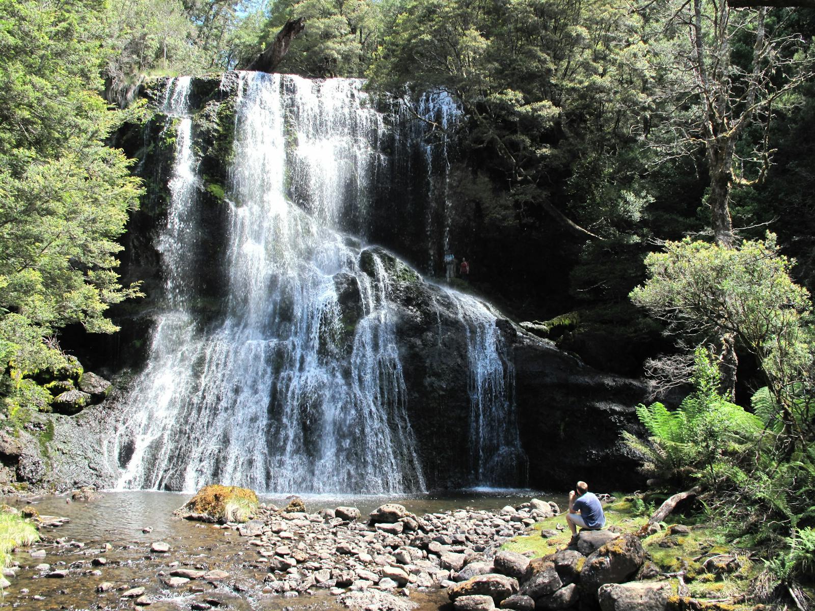Walker at waterfall in Tasmania