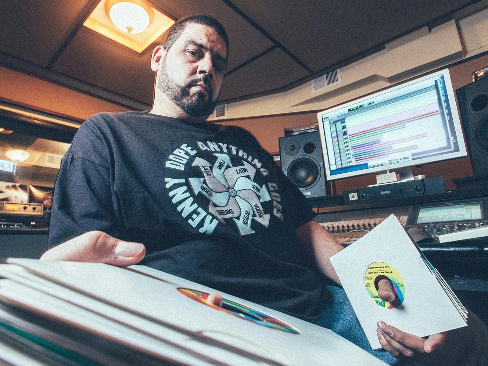 Kenny Dope sitting by computer and speakers at recording studio