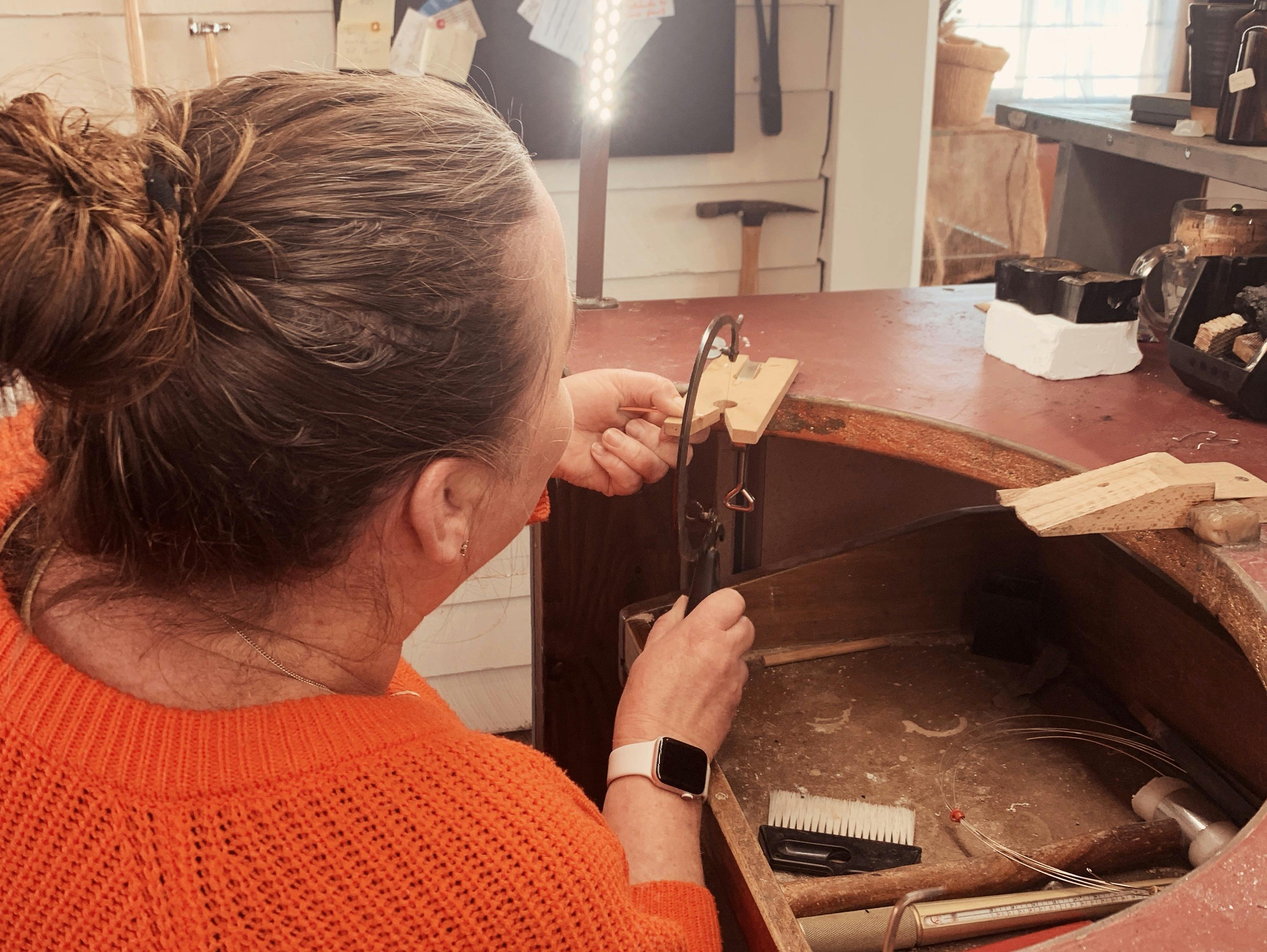 Shanyn Linklater Jewellery workshop attendee  using jewellers hand saw at