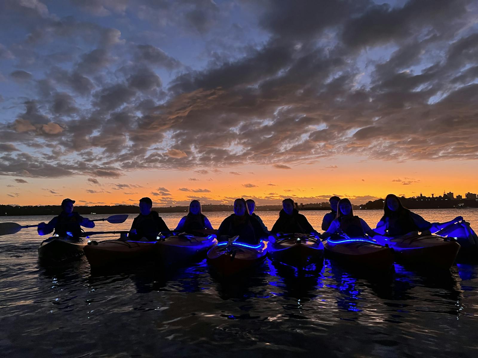 kayakers lining up at the golden glow of the sunrise