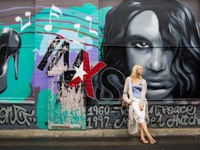Woman stating in front of street art on wall