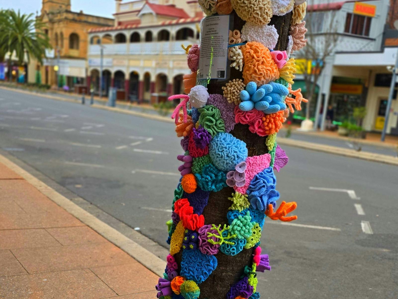 A tree in a street wrapped in crochet sea creatures A tree in a street wrapped in crochet sea creatures