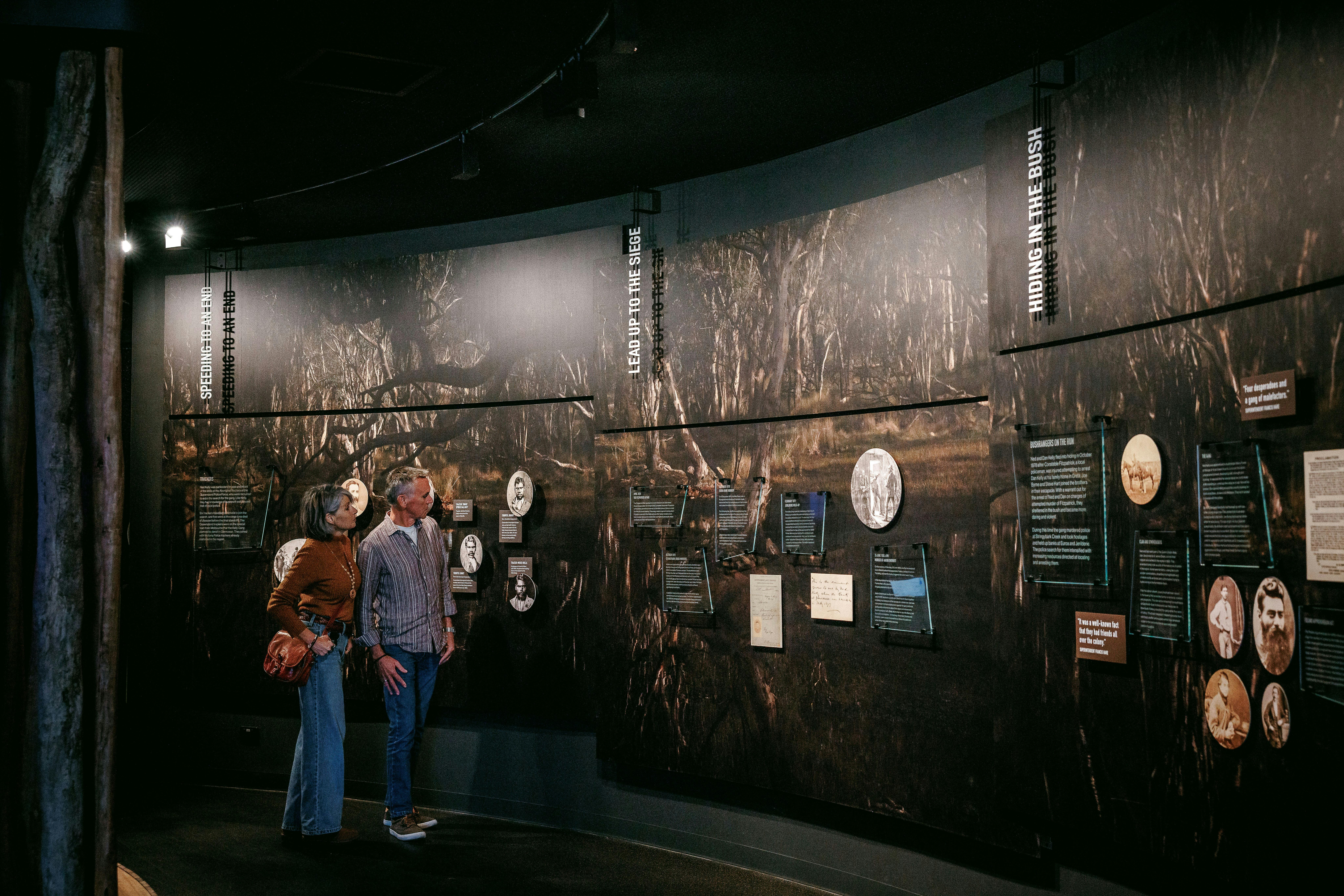 Interior of Ned Kelly Discovery Hub with visitors viewing historical displays, photos, and interpret