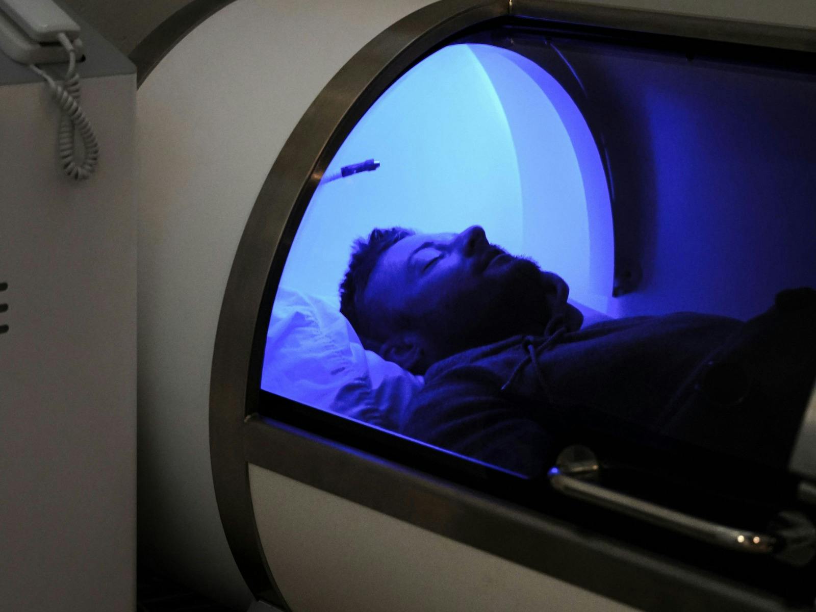 Client laying down in a Hyperbaric pod