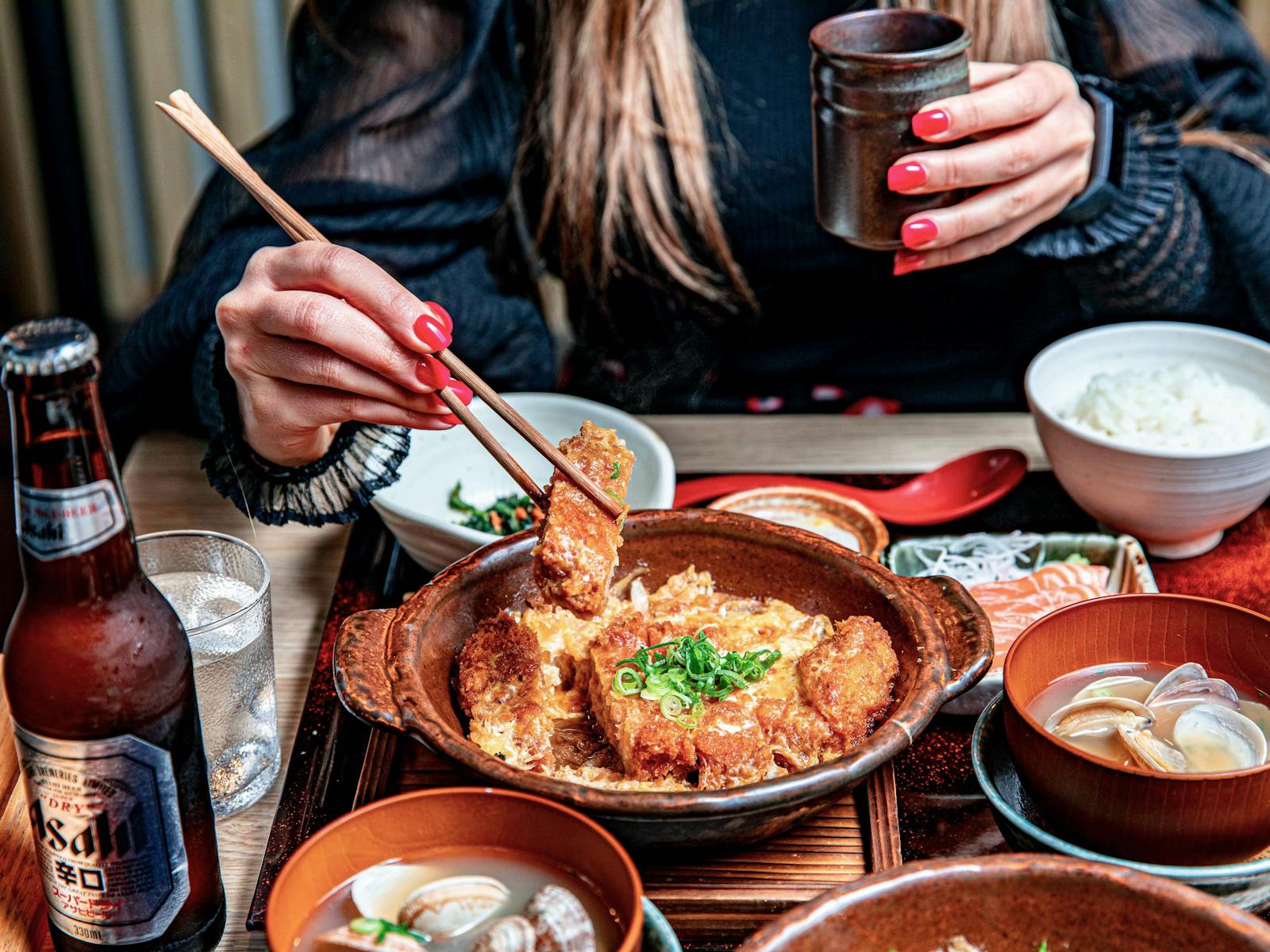 お箸で和食を食べる女性の写真