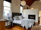 King size bed with gas log fire in the background