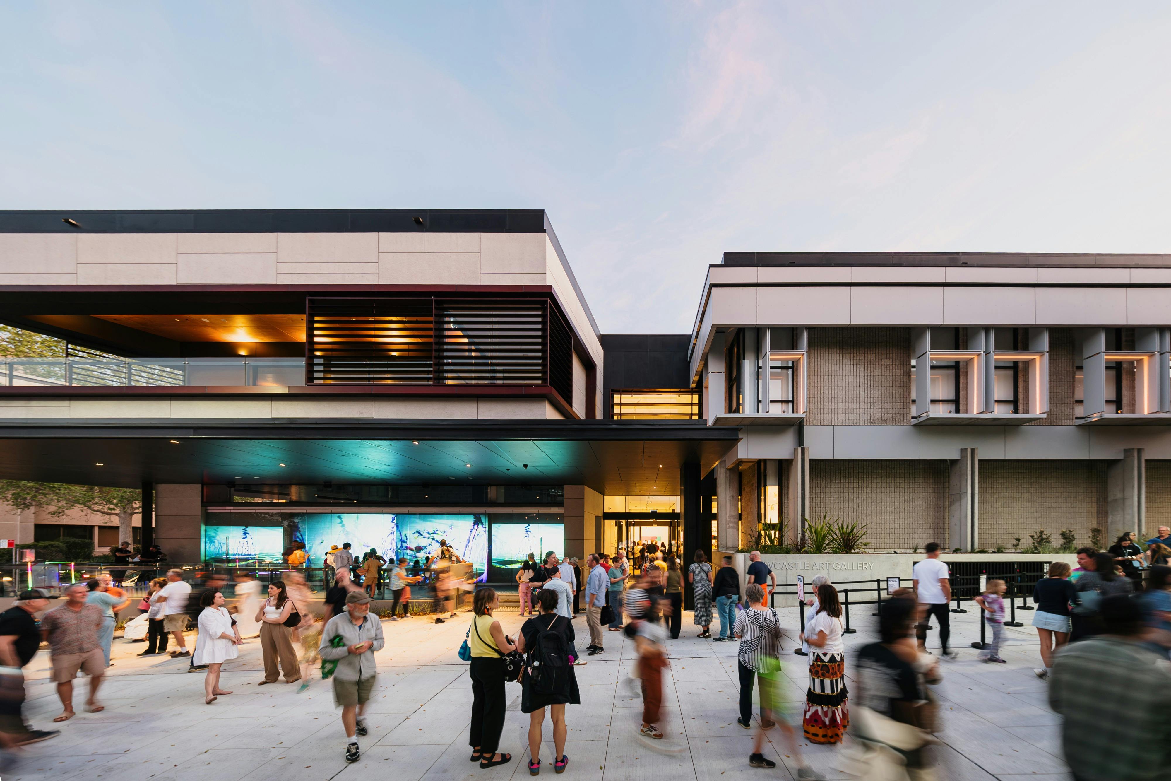 Image of the outside of Newcastle Art Gallery with crowds of people walking around.