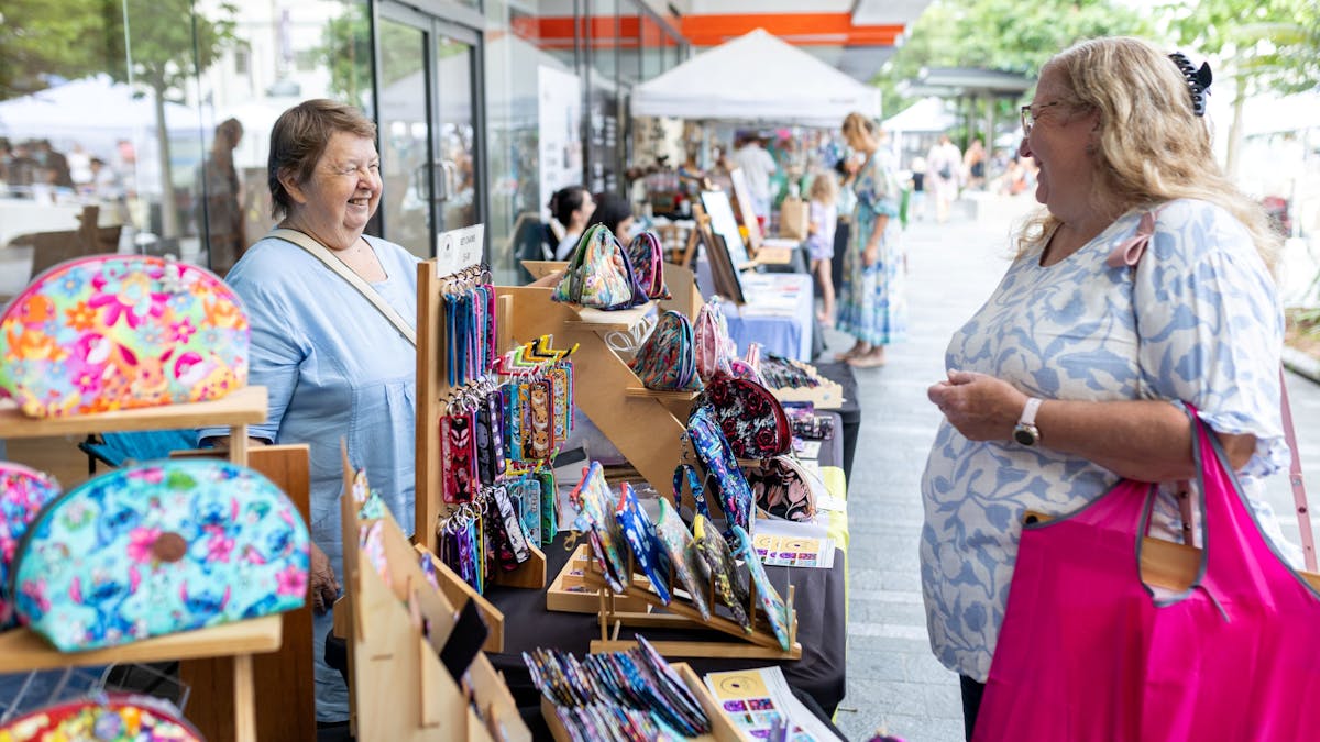 A shopper explores colourful handmade treasures at Cotters Market, Townsville