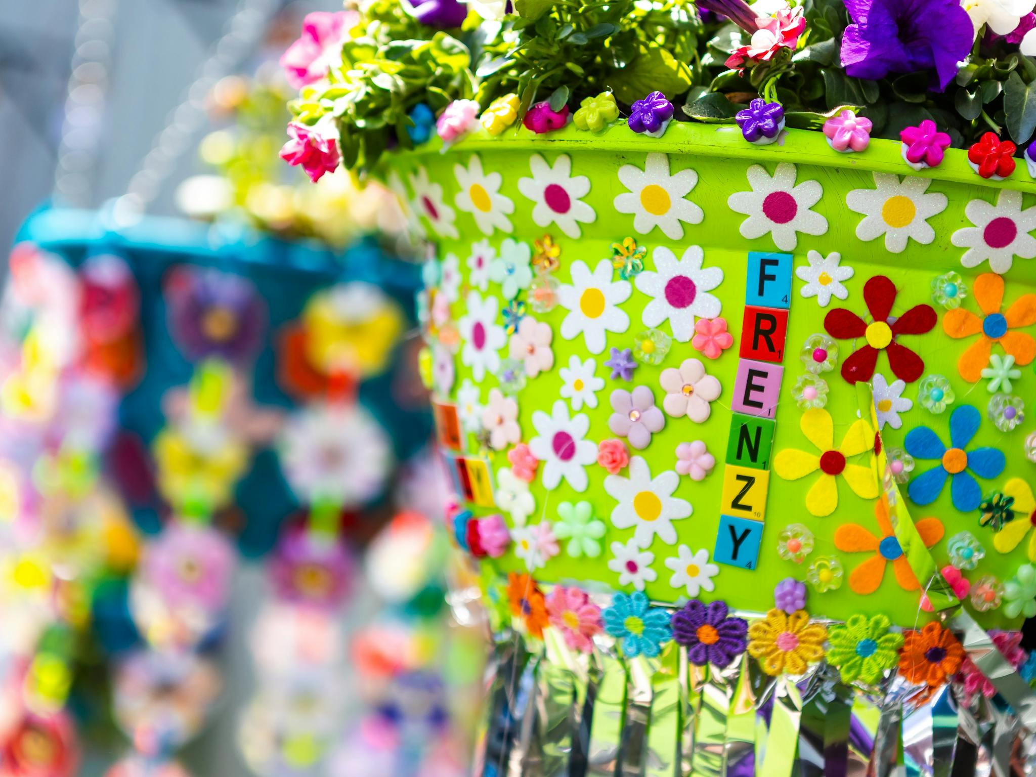 Green hanging flower basket with flower stickers and "FRENZY" spelled out on pot. Green hanging flower basket with flower stickers and "FRENZY" spelled out on pot.