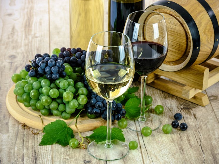 White wine with grapes and wine barrel