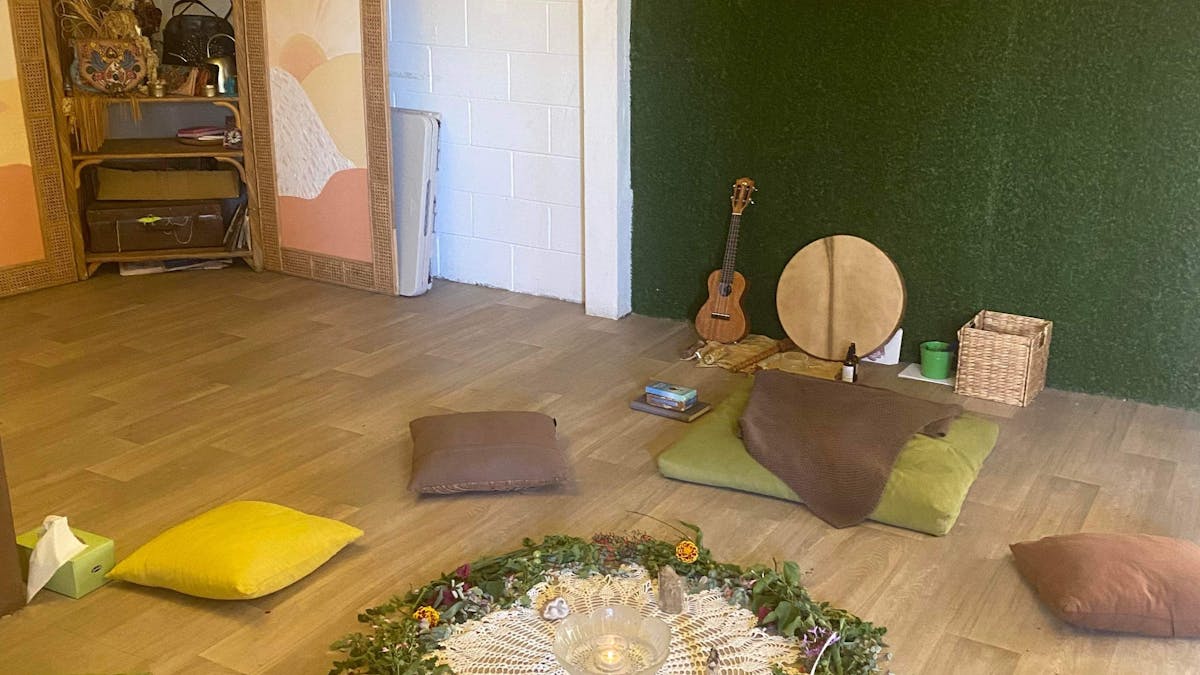 A relaxing image of a circle of dried florlas surrounded by cushions in a circle for a sound healing