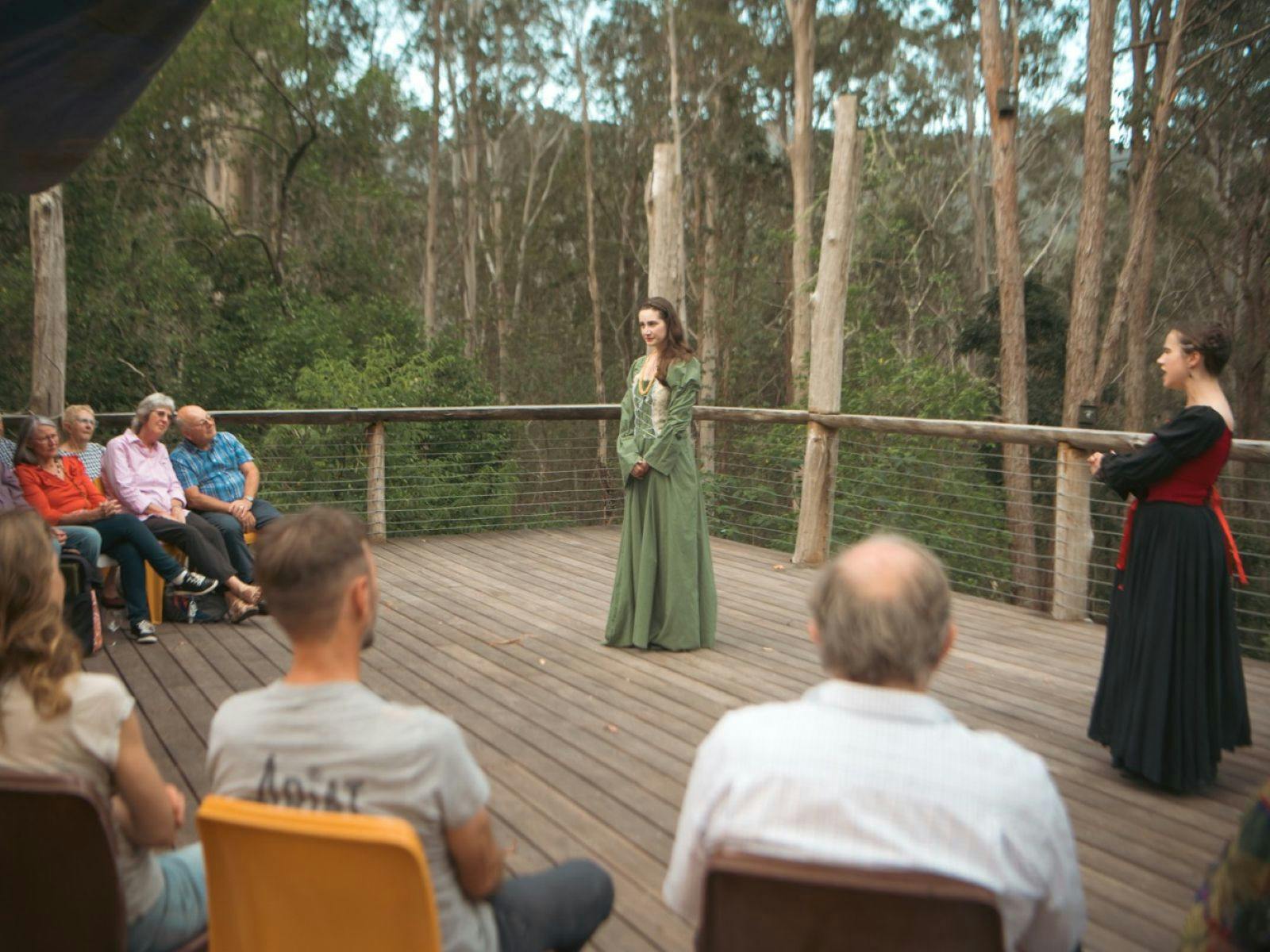 Audience watch actors performing Shakespeare in outdoor theater at Dungog Shakespearience, in forest