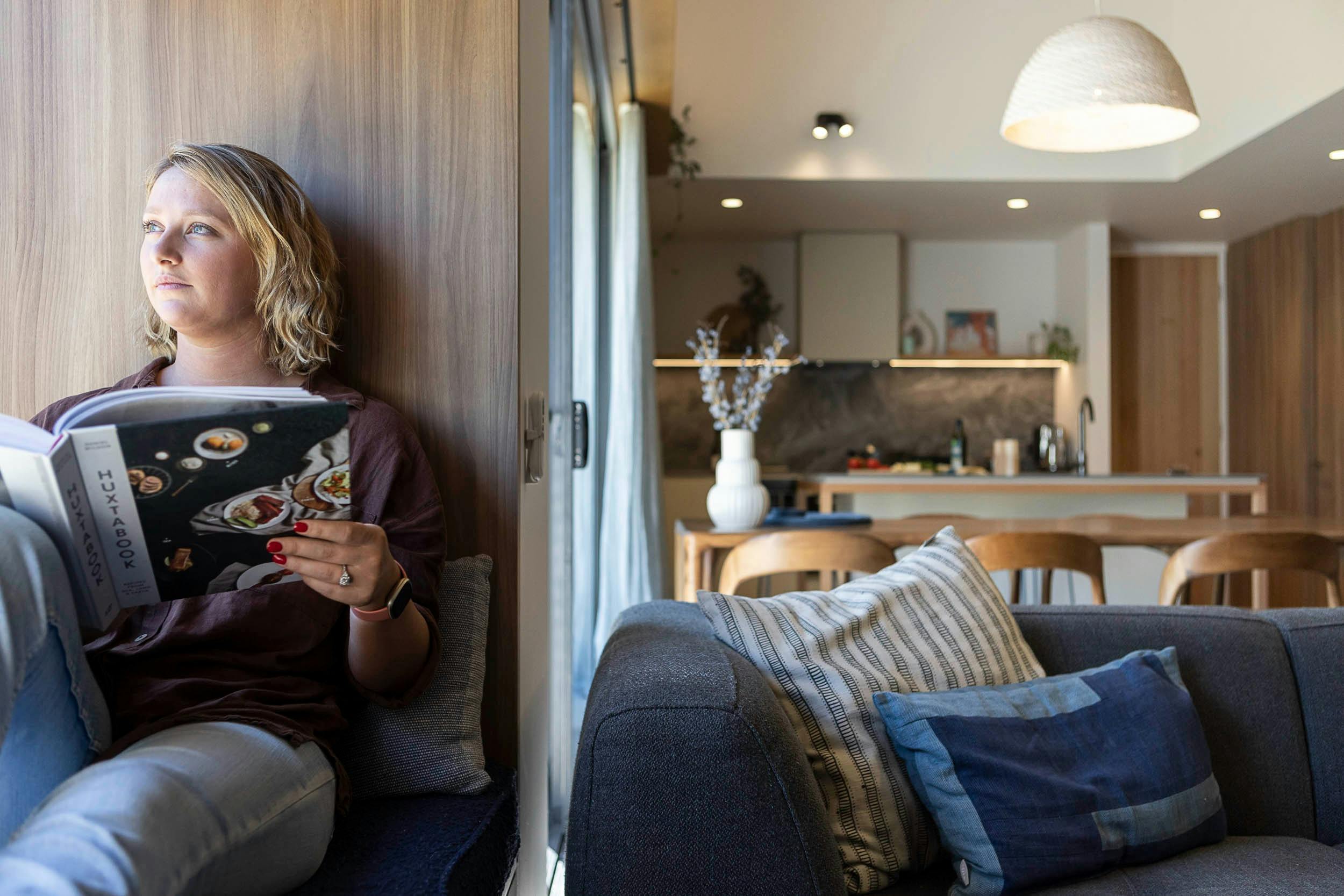 girl sitting in windowseat reading book
