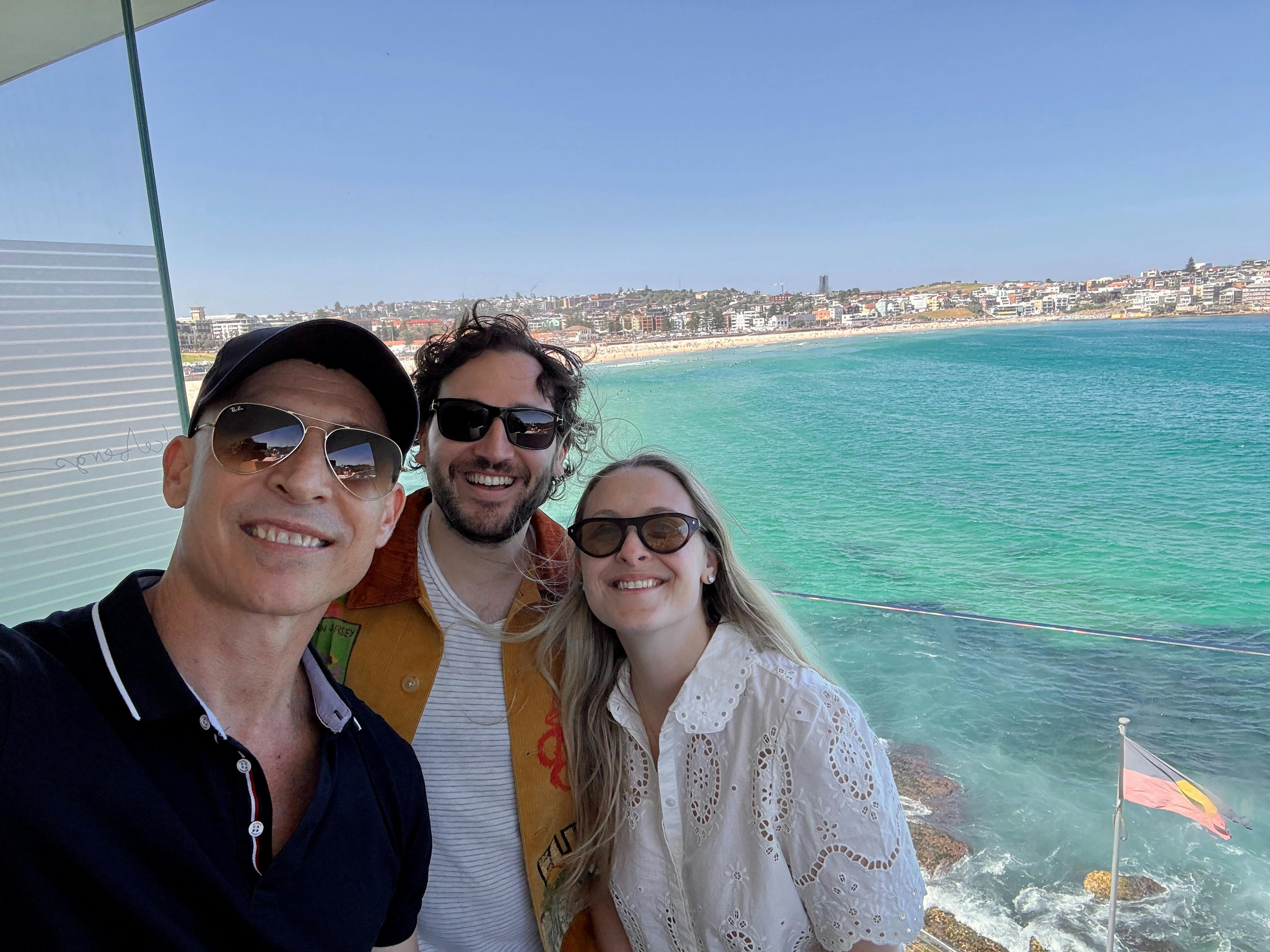 Three friends taking a selfie with Bondi Beach and turquoise water in the background