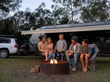 A family campsite set-up and enjoying the evening by the fire A family campsite set-up and enjoying the evening by the fire