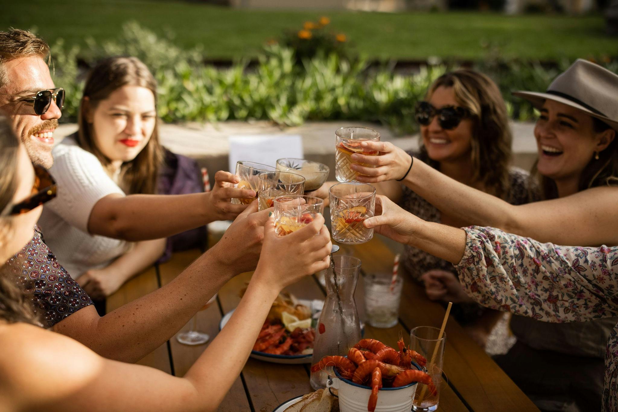 Group of people saying cheers with cocktails on the terrace
