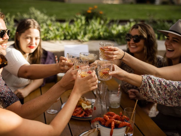 Group of people saying cheers with cocktails on the terrace