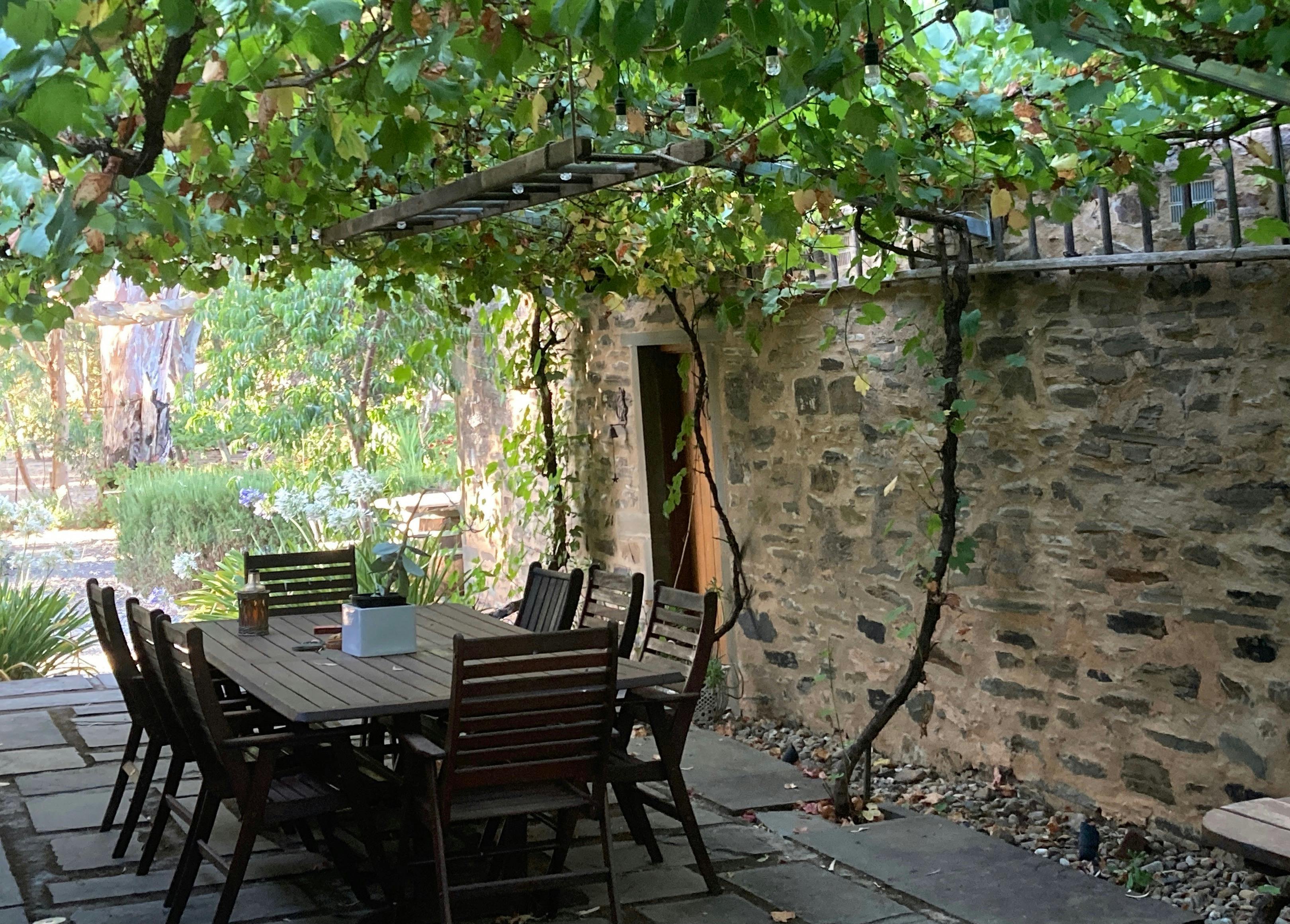 The western side of the stables has the entrance door and an outdoor table to use.