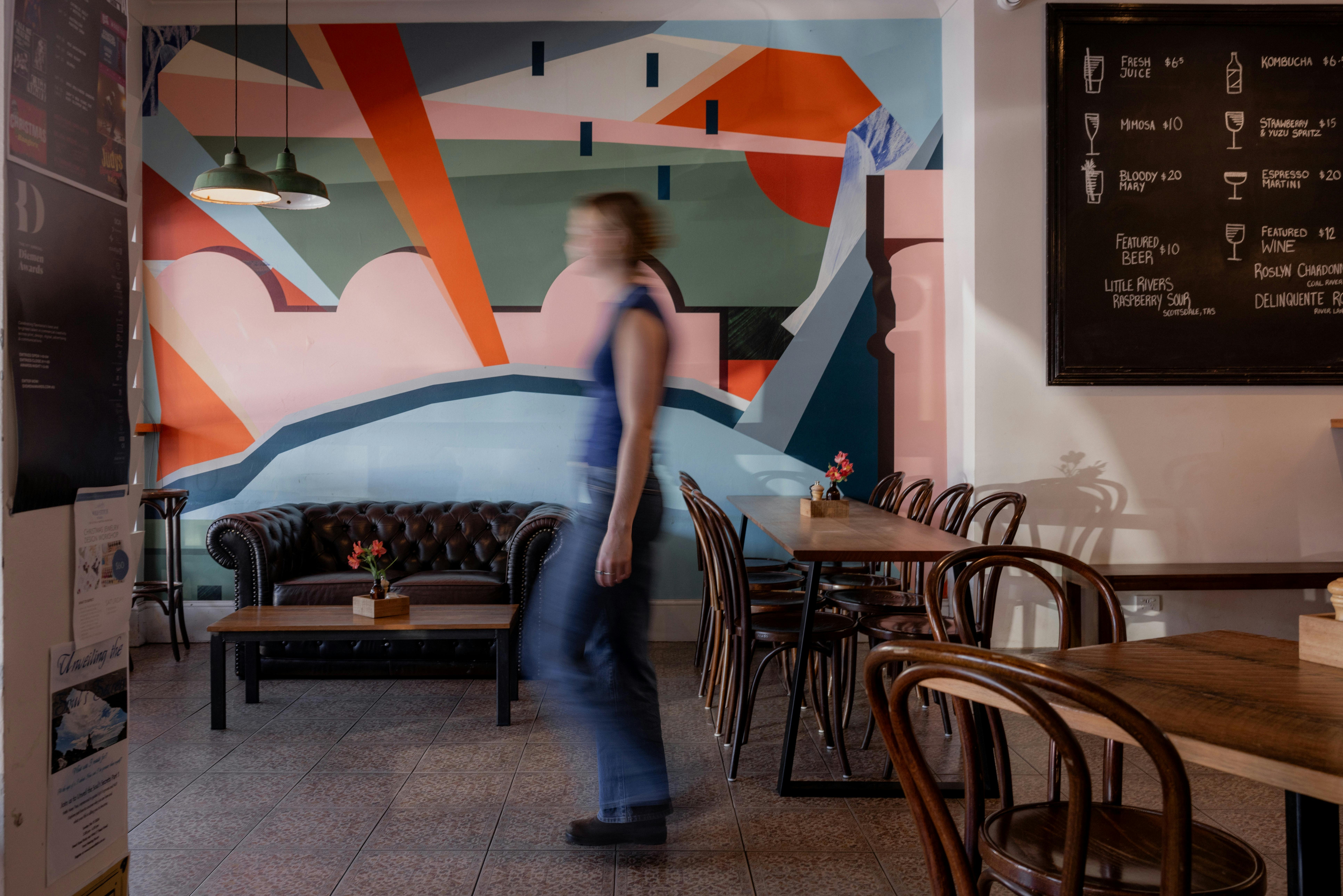 Colourful mural in cafe with girl moving in foreground