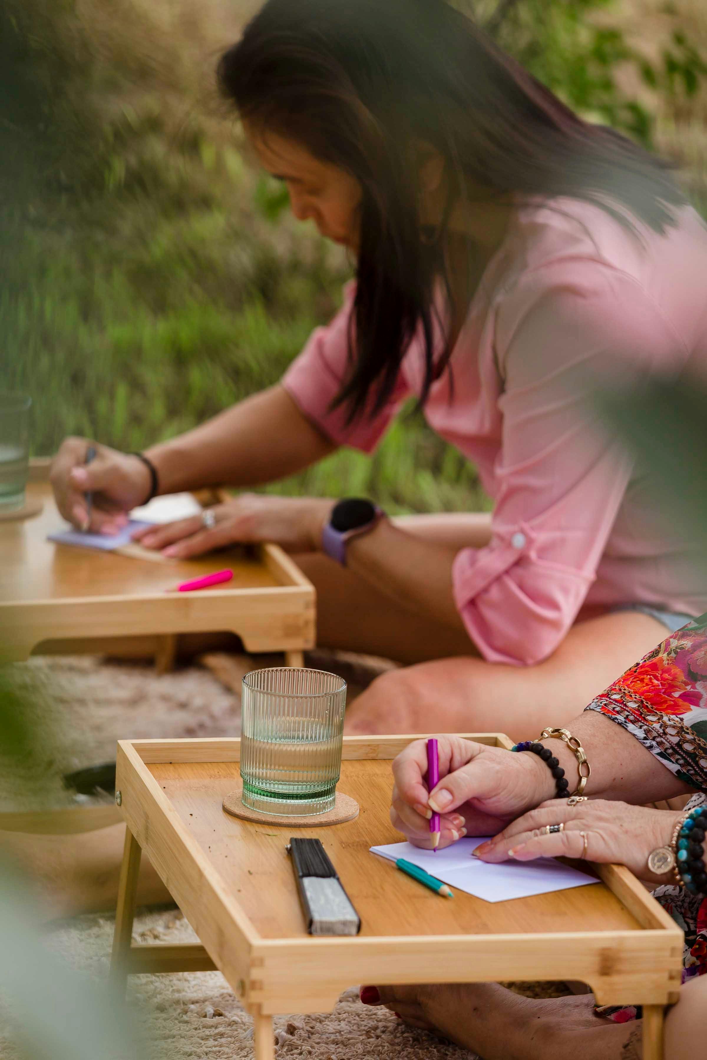 woman writing in a pink shirt