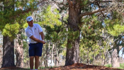 Male golfer chipping onto a green