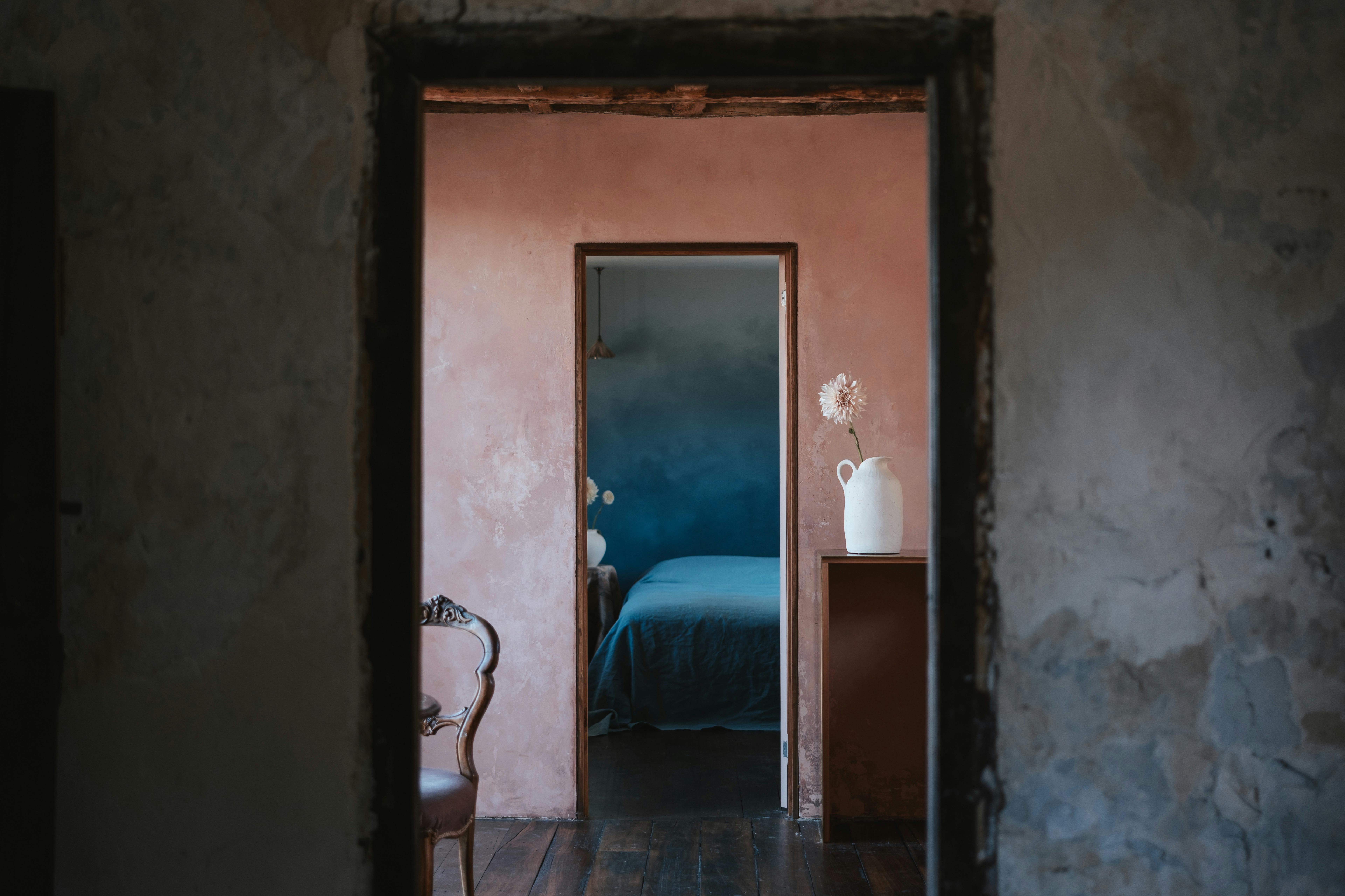 white wall in shade frames peach kitchen wall, which frames blue bedroom