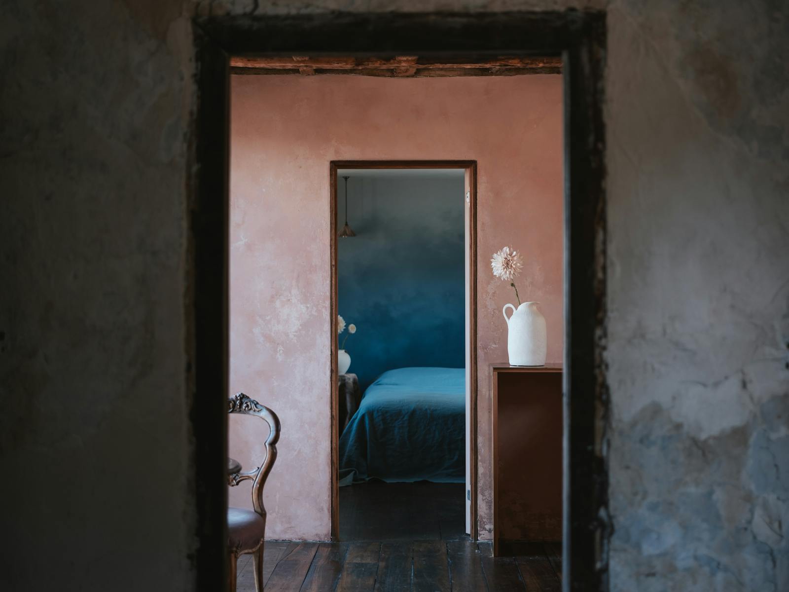 white wall in shade frames peach kitchen wall, which frames blue bedroom