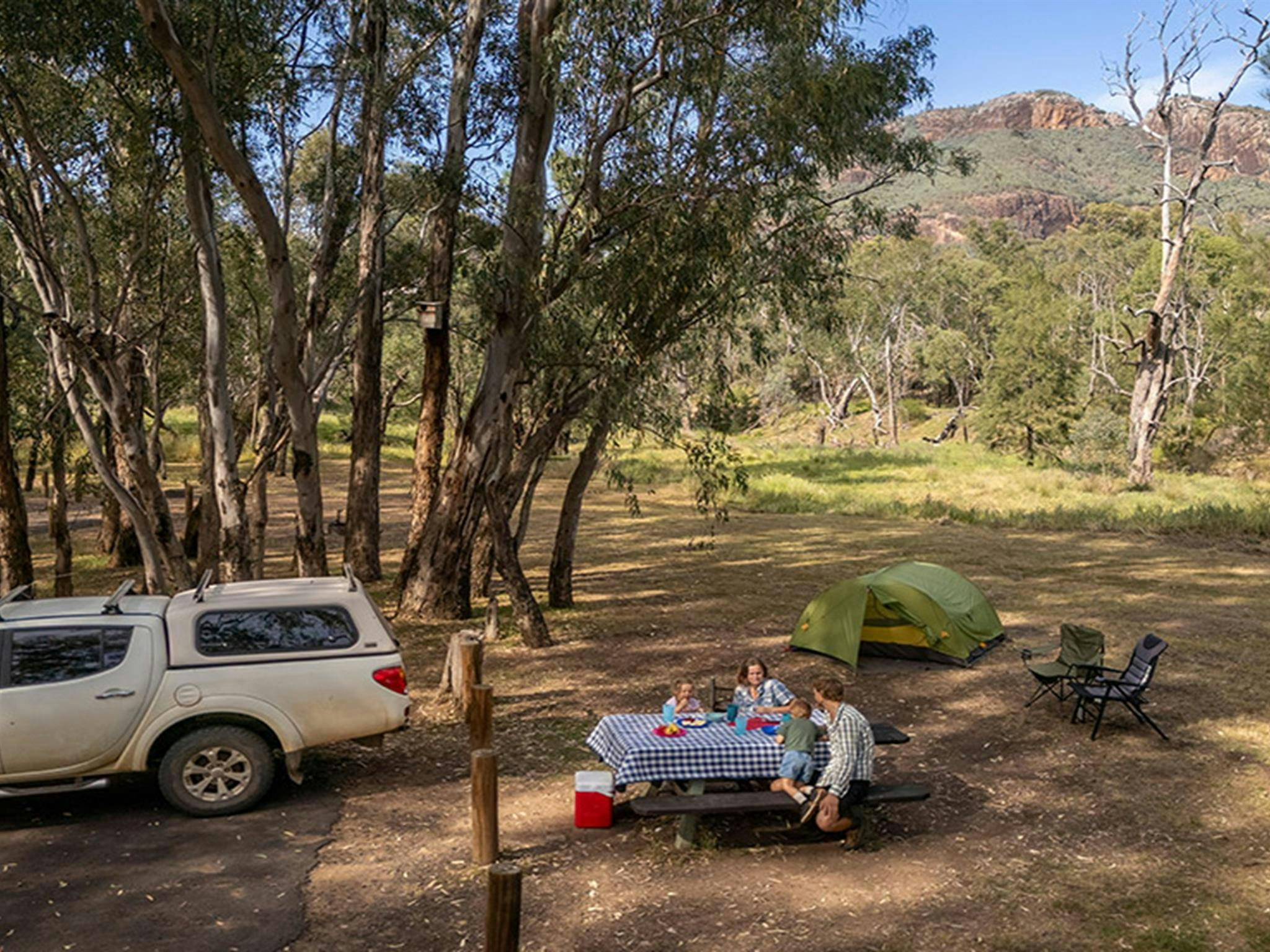 A family enjoying lunch at a picnic table, Camp Blackman. Credit: John Spencer &copy; DCCEEW