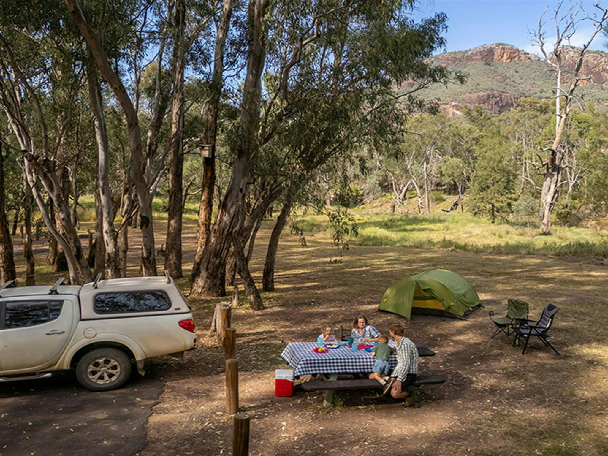 A family enjoying lunch at a picnic table, Camp Blackman. Credit: John Spencer &copy; DCCEEW