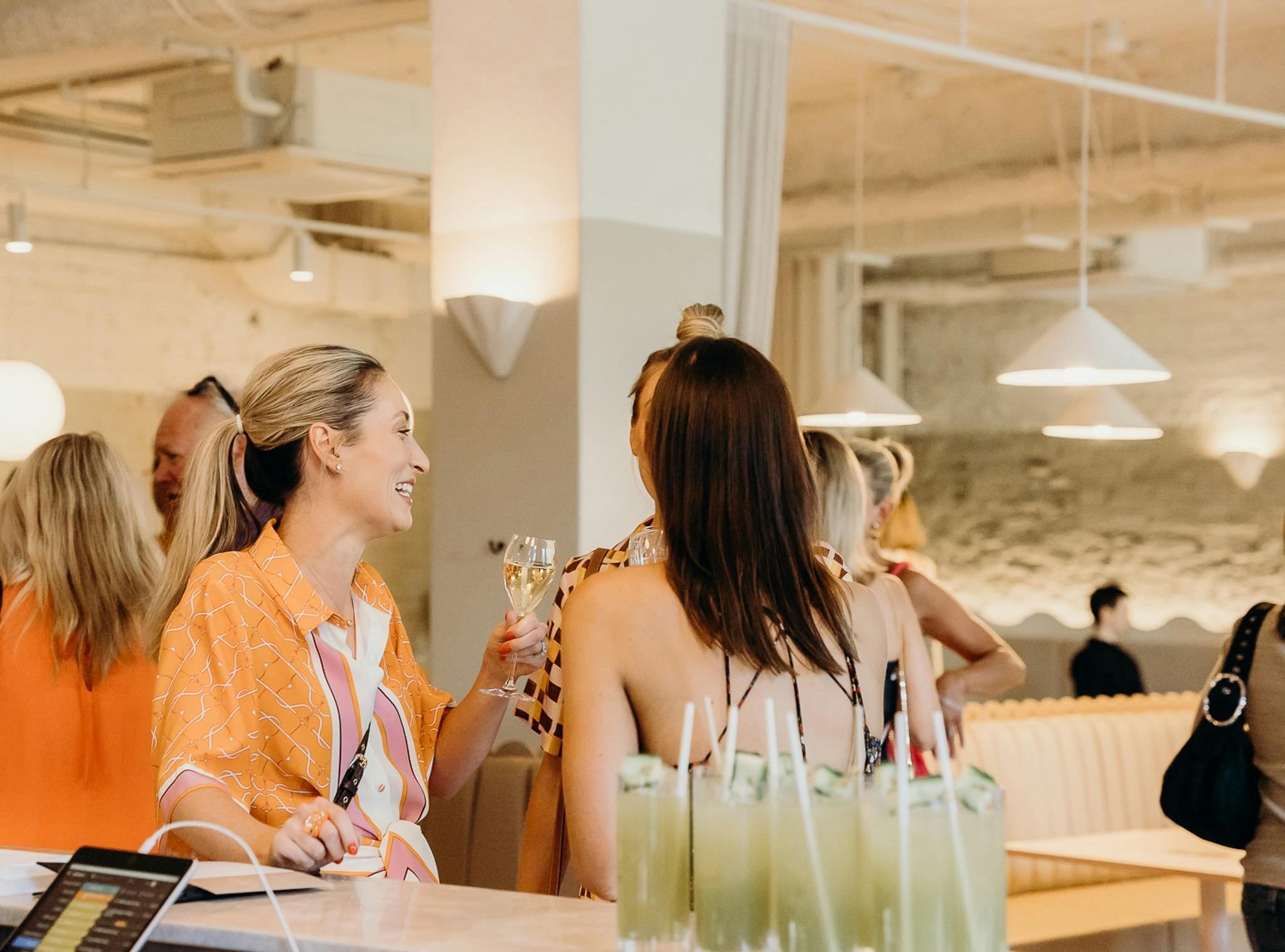 Three ladies toasting their drinks at the bar