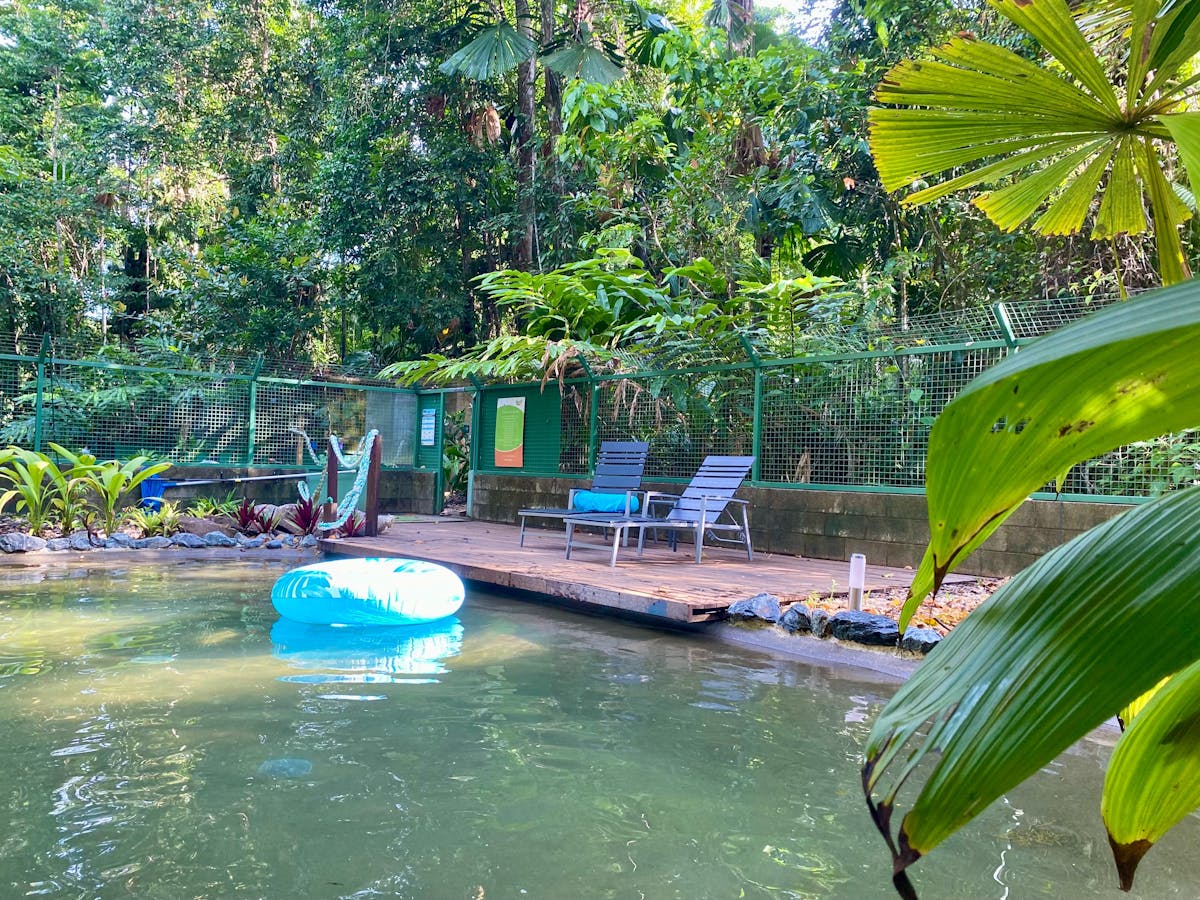 Swimming Pool with deck seating and float ring and green foliage