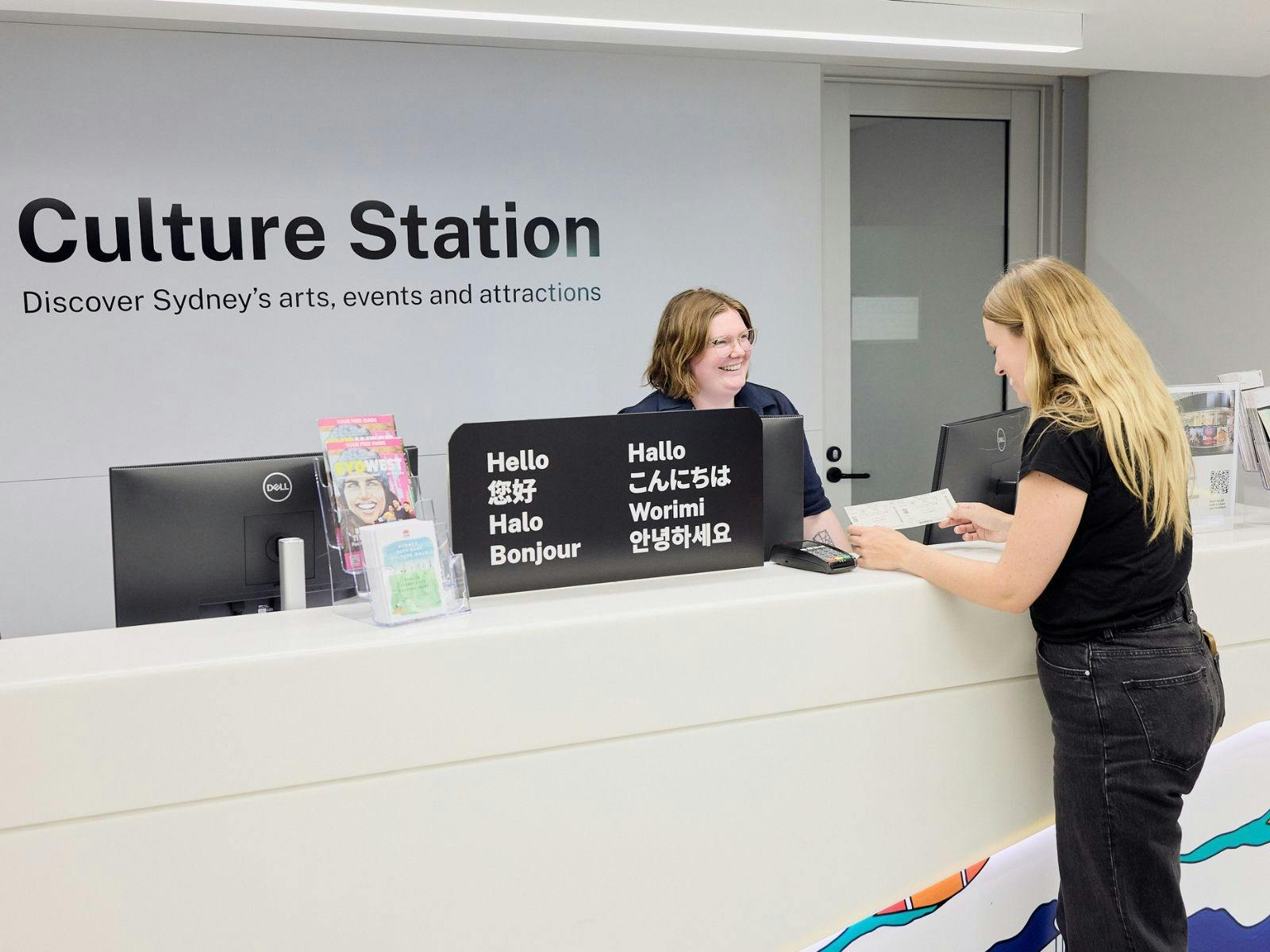 A women with blonde hair in an all black outfit purchasing tickets