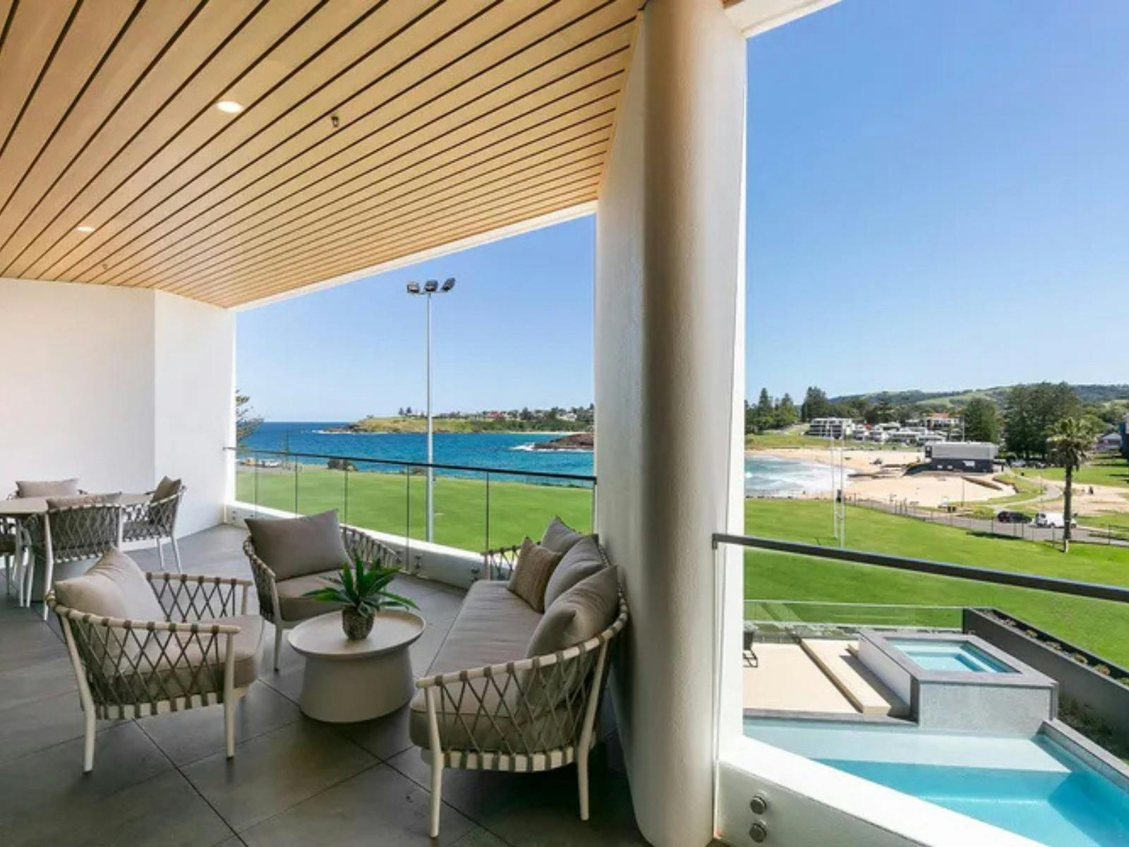 view of balcony with chairs and ocean views in the background