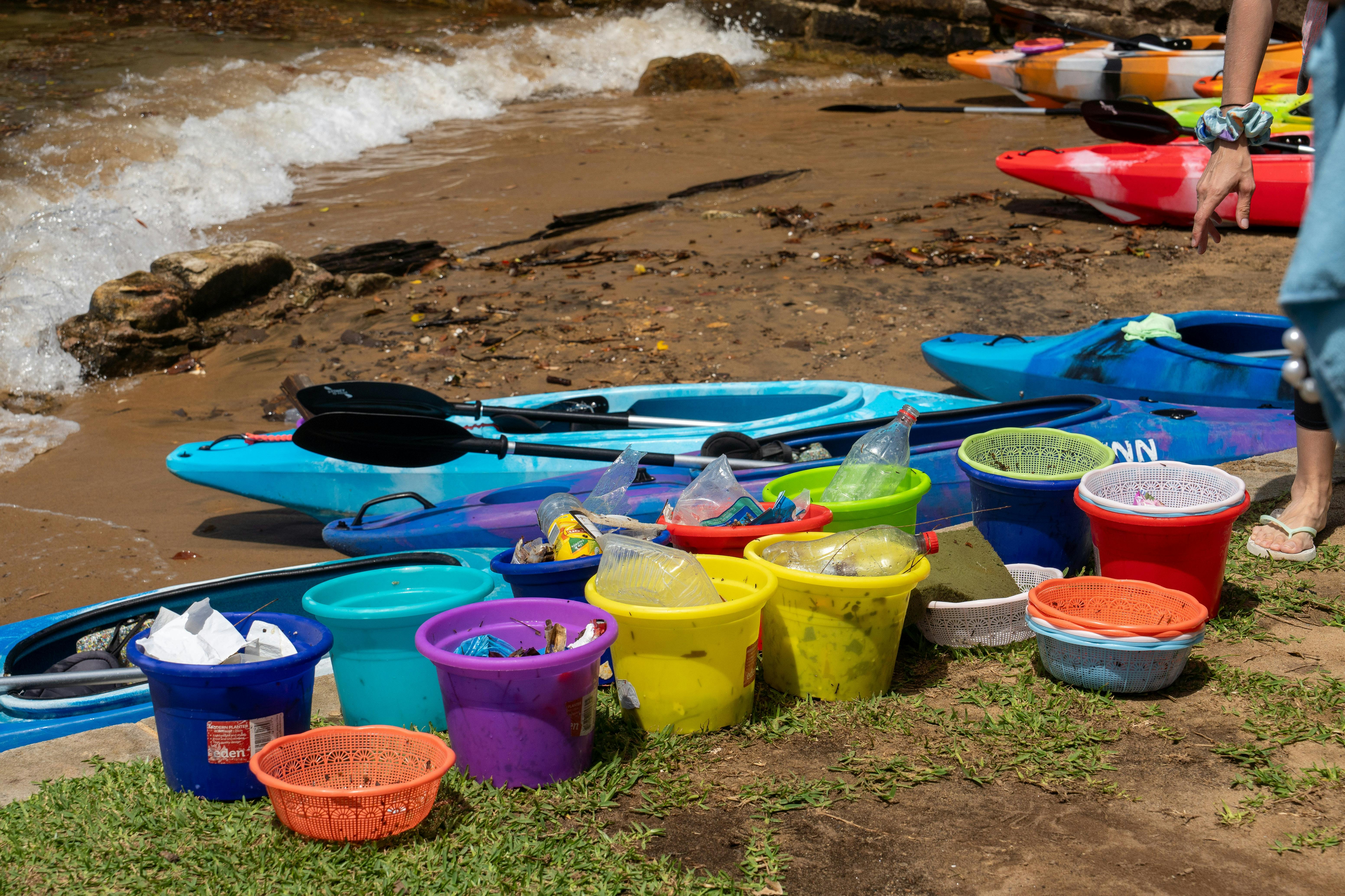 Bunte Eimer mit dem Müll von Kajakfahrern, die während der Sydney By Kayak Corporate Clean-up Paddle gesammelt wurden