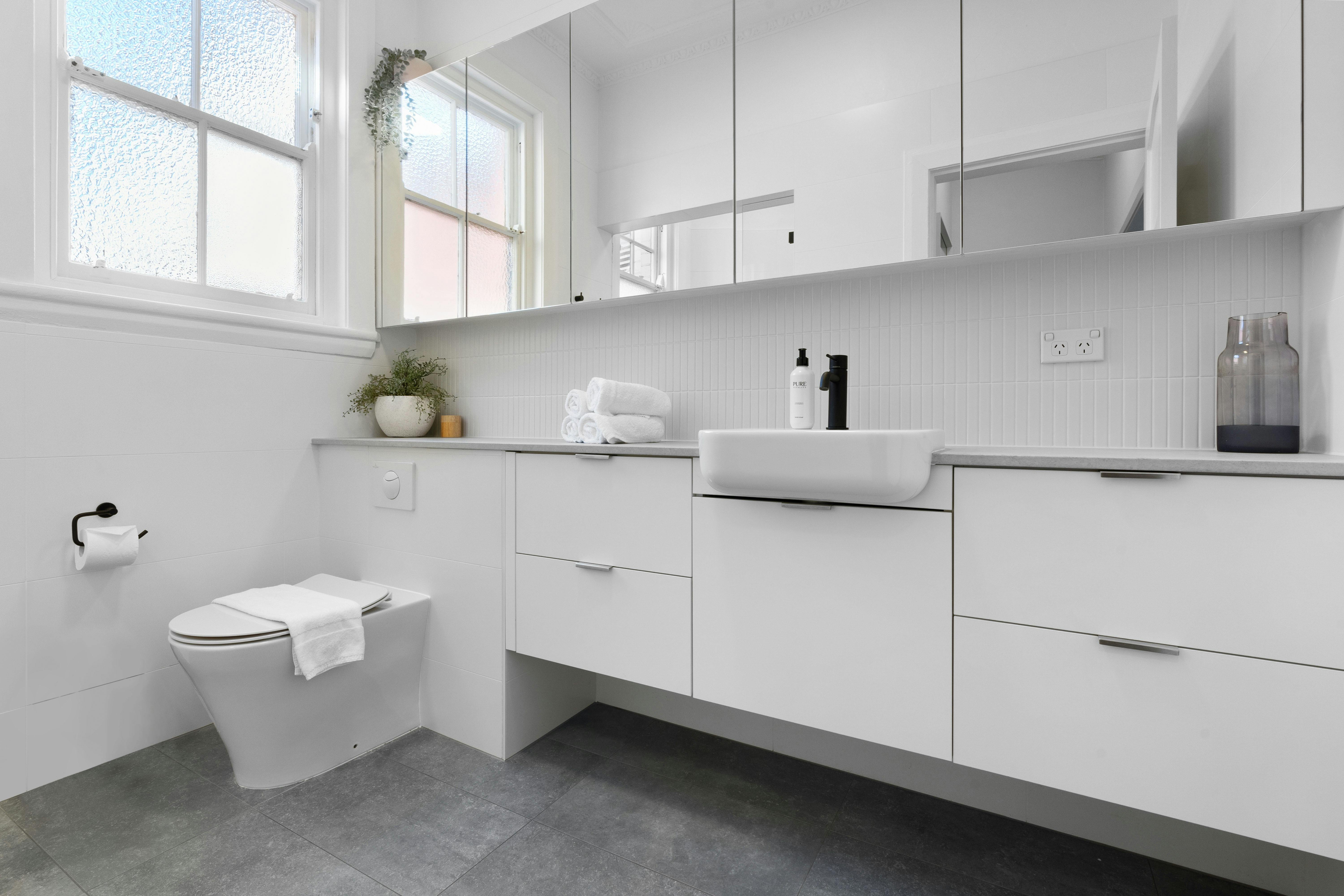 Sleek white bathroom with modern sink and storage for a clean look.