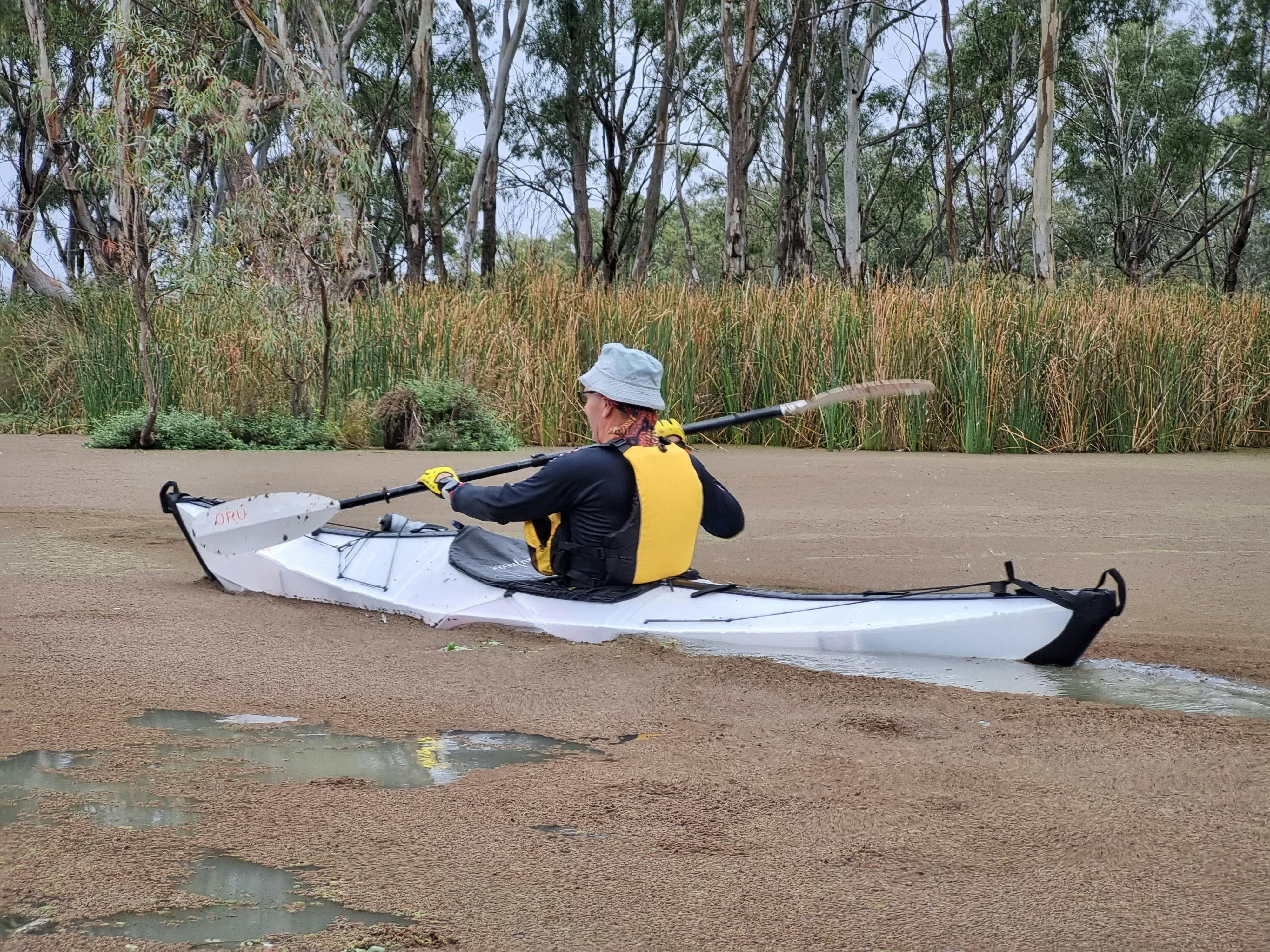 Single kayaker paddling in duck weed near Loch Luna