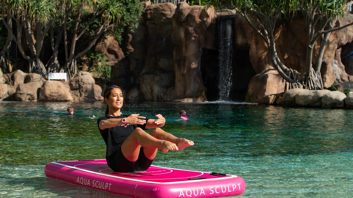 Participant in a yoga pose and balance challenge at a pool in Surfers Paradise